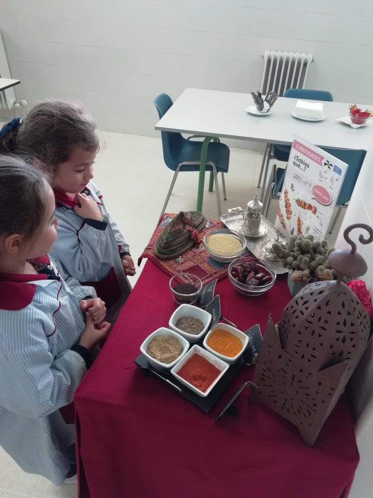 Niños ante una mesa de especias.